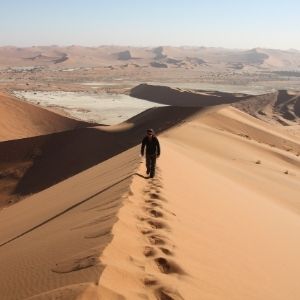 Persoon wandelt over een duin in de Sossusvlei